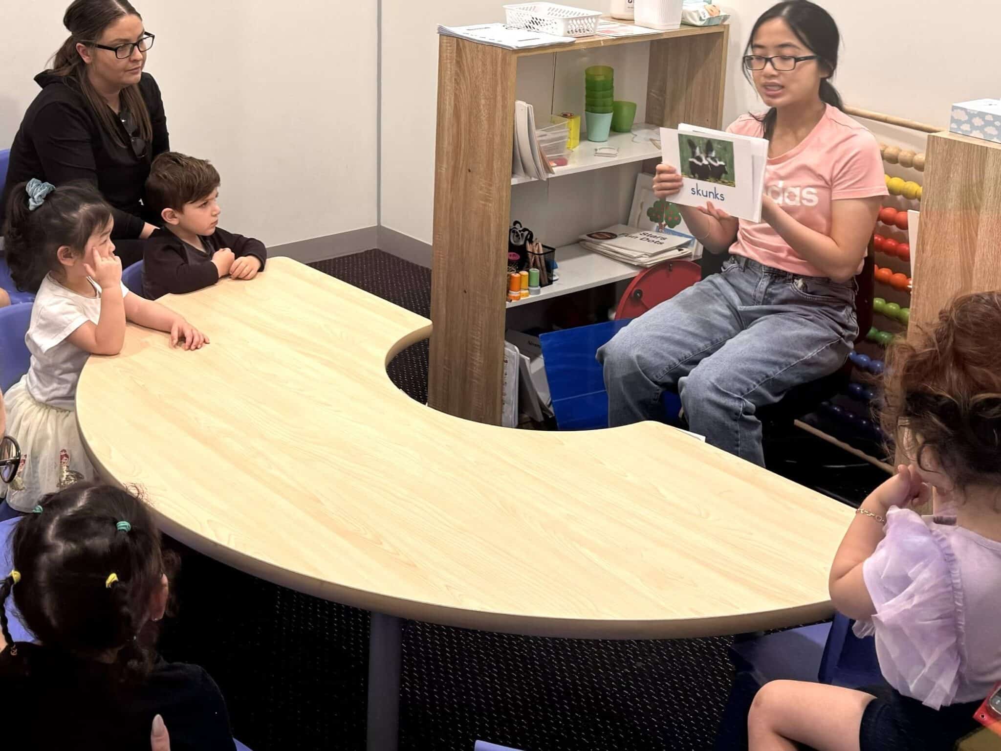 Young kids watching a Shichida teacher flash a stack of flashcards in a class