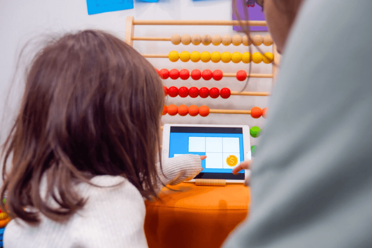 Concentration for kids activities good screen time example of a child pointing to a screen, she is playing a digital memory game with her mum