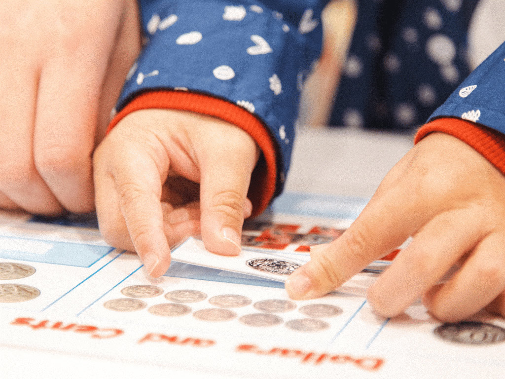 A Money play activity for preschoolers using laminated cutouts to match money with in a Shichida class