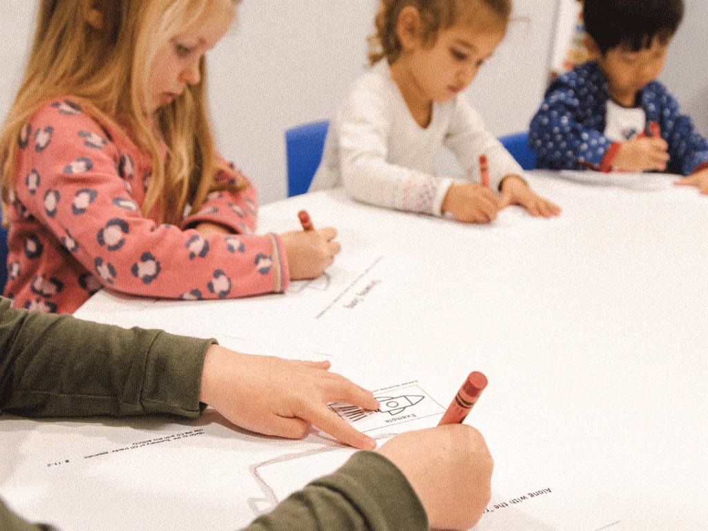 Preschoolers kids drawing with guidance in a Shichida class