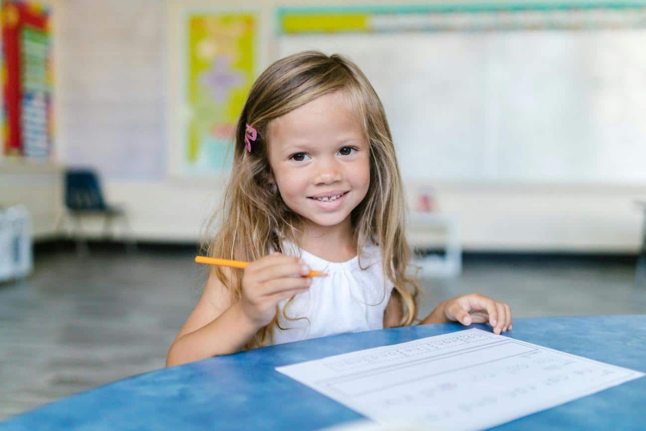 Blonde Girl Holding a Pencil, practicing her pencil grip development