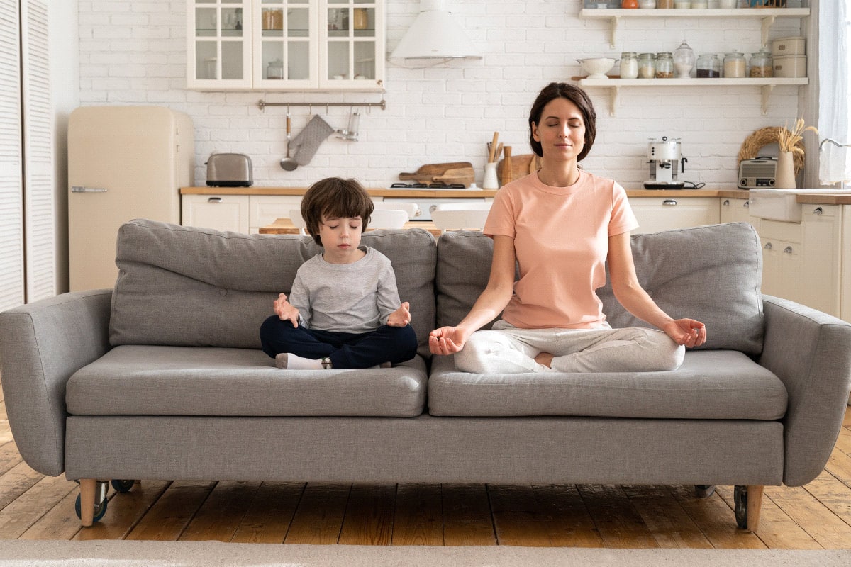 Practising emotional regulation through meditation, here a mum and child practise relaxation together.