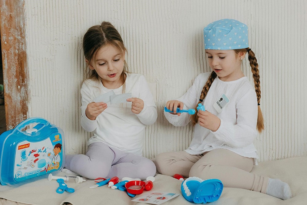 Imaginative play for toddlers - two girls playing with Doctor toys