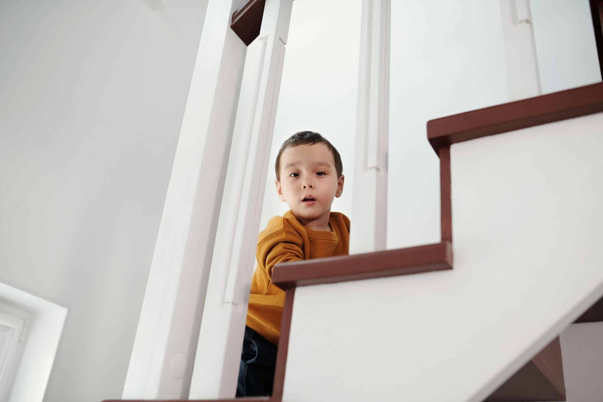 Stages of child development guide, featuring a young child climbing stairs.
